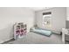 Bright bedroom featuring a twin mattress, decorative shelving, and a large window with neighborhood views at 6713 Cardiff Dr, McCordsville, IN 46055
