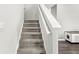 Carpeted staircase with white railing leads to the next level, showcasing the home's functional design at 6713 Cardiff Dr, McCordsville, IN 46055