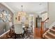 Elegant dining room featuring hardwood floors, a modern chandelier, and stairs leading to the lower level at 681 Greenford N Trl, Carmel, IN 46032