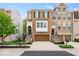 Charming brick townhome featuring a two-car garage, covered entrance, and well-manicured landscaping at 681 Greenford N Trl, Carmel, IN 46032