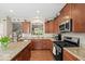 Well-lit kitchen with granite countertops, stainless steel appliances, hardwood floors, and a center island at 681 Greenford N Trl, Carmel, IN 46032