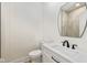 Stylish powder room featuring white vanity, black faucet and hardware, and a modern mirror at 711 N Fenton Ave, Indianapolis, IN 46219