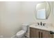 Stylish half-bathroom featuring a modern vanity, toilet, and a decorative mirror at 711 N Fenton Ave, Indianapolis, IN 46219