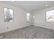 Bright bedroom with neutral carpet, white walls, and three windows providing natural light at 711 N Fenton Ave, Indianapolis, IN 46219
