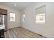 Bright dining area with large windows, wood floors, and stainless steel refrigerator at 711 N Fenton Ave, Indianapolis, IN 46219