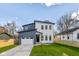 Two-story home featuring a two-car garage, stylish gray and white siding, and a well-manicured lawn at 711 N Fenton Ave, Indianapolis, IN 46219