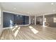 Bright open-concept living room with blue accent wall, wooden shelves, and hardwood floors at 711 N Fenton Ave, Indianapolis, IN 46219
