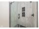 Modern shower featuring a glass door and tile surround with built in storage at 711 N Fenton Ave, Indianapolis, IN 46219