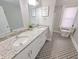 Bathroom with granite countertop, double vanity, and patterned floor tiles at 726 E Mccarty St, Indianapolis, IN 46203