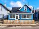 Charming two-story blue home with a well-manicured lawn, a black roof, and a partially fenced yard at 726 E Mccarty St, Indianapolis, IN 46203