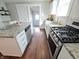 Bright kitchen with white cabinets, granite counters, hardwood floors, and modern stainless-steel appliances at 726 E Mccarty St, Indianapolis, IN 46203