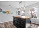 View of the kitchen island with wood top, pendant lights, and seating at 7711 Winterberry Ct, Noblesville, IN 46062