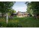 Large backyard featuring a brick home, patio, pergola, mature trees, and swing set at 7971 Clearwater Ct, Indianapolis, IN 46256
