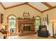 Inviting living room featuring vaulted ceilings, a brick fireplace, and arched windows at 7971 Clearwater Ct, Indianapolis, IN 46256