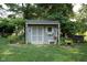Charming backyard shed with double doors, window box, bench, and landscaped garden bed at 7971 Clearwater Ct, Indianapolis, IN 46256