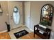 Welcoming foyer with a Hello mat, decorative table, and an oval glass front door at 8960 Stepping Stone Way, Avon, IN 46123