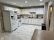 Well-lit kitchen with white cabinets, modern appliances, and sleek tile flooring at 8960 Stepping Stone Way, Avon, IN 46123