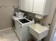 Functional laundry room featuring a modern washer, sink, storage cabinets, and stylish floors at 8960 Stepping Stone Way, Avon, IN 46123