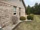 Landscaped side yard with stone decor, trees and brick exterior at 8960 Stepping Stone Way, Avon, IN 46123
