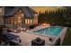 Luxurious backyard featuring a sparkling swimming pool, a cozy fire pit, and comfortable patio furniture at 10802 Giselle Way, Fishers, IN 46040