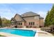 Backyard view with a pool, manicured lawn, patio area, screened-in porch, and plenty of room for outdoor activities at 10802 Giselle Way, Fishers, IN 46040