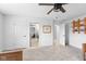 Carpeted bedroom with connecting doors, ceiling fan, and decor shelving at 10802 Giselle Way, Fishers, IN 46040