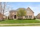 Beautiful two-story brick home with lush green lawn and manicured landscaping enhances its curb appeal at 10802 Giselle Way, Fishers, IN 46040