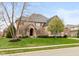 Beautiful brick home with manicured lawn and mature trees on a sunny day at 10802 Giselle Way, Fishers, IN 46040