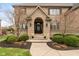 Charming brick home featuring an arched front entry, landscaped flower beds, and a well-maintained lawn at 10802 Giselle Way, Fishers, IN 46040