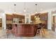 Expansive kitchen featuring a large island, dark wood cabinets, and stainless appliances at 10802 Giselle Way, Fishers, IN 46040