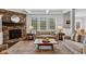 Cozy living room with a stone fireplace, comfortable seating, and large windows offering natural light at 10802 Giselle Way, Fishers, IN 46040