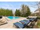 Inviting backyard with a refreshing swimming pool, comfortable lounge chairs, and a well-manicured lawn at 10802 Giselle Way, Fishers, IN 46040