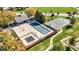 Aerial view of the neighborhood pool area featuring pool, lounge area, pool house, basketball court and manicured landscaping at 12396 Dellfield W Blvd, Carmel, IN 46033