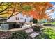 Inviting backyard features a paver patio with seating and a fire pit, all shaded by mature trees with colorful fall foliage at 12396 Dellfield W Blvd, Carmel, IN 46033