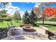Backyard patio featuring a stone fire pit, chairs, and stone retaining wall for seating area at 12396 Dellfield W Blvd, Carmel, IN 46033