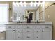 Bright bathroom featuring a double vanity with granite countertops, white cabinetry, and decorative accents at 12396 Dellfield W Blvd, Carmel, IN 46033