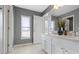 Well-lit bathroom featuring a double sink vanity, marble countertops, and natural light from a nearby window at 12396 Dellfield W Blvd, Carmel, IN 46033