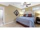 A well-lit bedroom features a ceiling fan, neutral color palette and an upholstered headboard on the bed at 12396 Dellfield W Blvd, Carmel, IN 46033