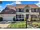 Charming two-story home featuring a brick facade, well-manicured lawn, and an attached two-car garage at 12396 Dellfield W Blvd, Carmel, IN 46033