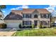 Charming two-story brick home featuring a well-maintained lawn, attached garage, and lovely landscaping at 12396 Dellfield W Blvd, Carmel, IN 46033