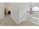 Bright hallway with white railing, staircase, and chandelier at 12396 Dellfield W Blvd, Carmel, IN 46033