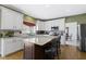 Bright kitchen featuring white cabinets, granite countertops, stainless appliances, and a large island with seating at 12396 Dellfield W Blvd, Carmel, IN 46033