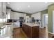 Open kitchen with white cabinets, granite countertops, stainless appliances, and island with bar stool seating at 12396 Dellfield W Blvd, Carmel, IN 46033