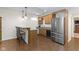 A cozy kitchenette features stainless steel appliances, a wine refrigerator, a granite countertop, and warm, wood-toned cabinetry at 12396 Dellfield W Blvd, Carmel, IN 46033