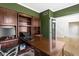 Office with custom wood built-ins, a large desk, green walls, and hardwood floors at 12396 Dellfield W Blvd, Carmel, IN 46033