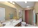 Well-lit bathroom with a large mirror, vanity with sink, toilet, and shower-tub combination at 13504 E 131St St, Fishers, IN 46037