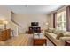 Cozy living room showcasing a comfortable sofa, hardwood floors, and staircase leading to upper level at 13504 E 131St St, Fishers, IN 46037