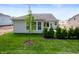 Backyard featuring a lush lawn, decorative shrubbery, and a light-colored exterior with dark roof at 14383 Coyote Ridge Dr, Noblesville, IN 46060