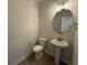 Powder room featuring tile floors, toilet, and a pedestal sink with an oval mirror at 14383 Coyote Ridge Dr, Noblesville, IN 46060
