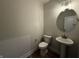 Half bath with a pedestal sink and decorative round mirror at 14383 Coyote Ridge Dr, Noblesville, IN 46060